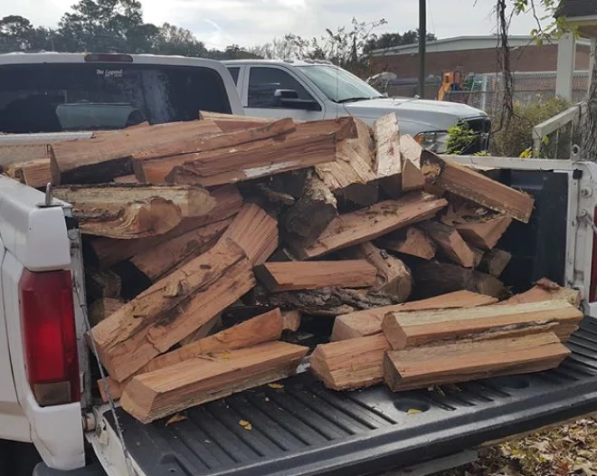 newly cut firewoods loaded at the back of a pickup truck
